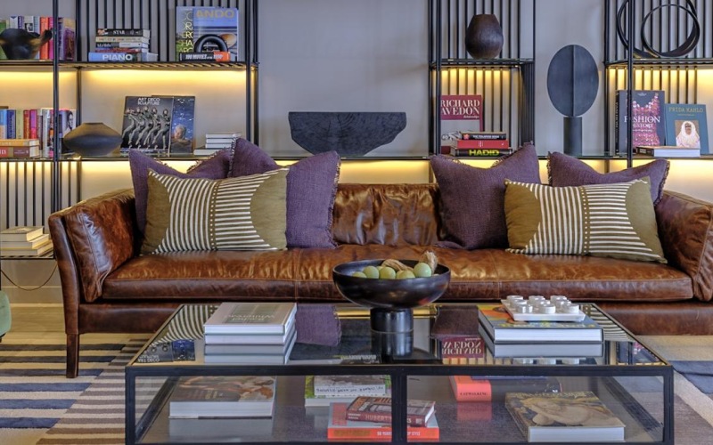 a lounge with seating and shelving behind it