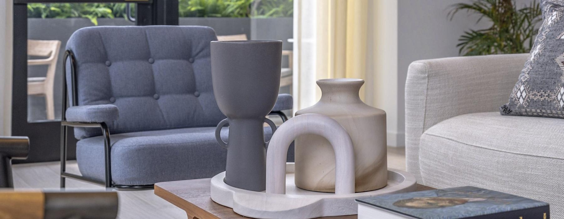 a living room with a vase and books on a coffee table